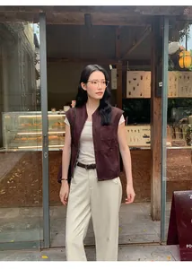 Gilet di tendenza in camoscio viola Maillard su top bianco in ambiente da caffè