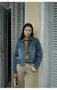 Outdoor street style shot of a woman wearing a vintage blue gradient wash denim short jacket