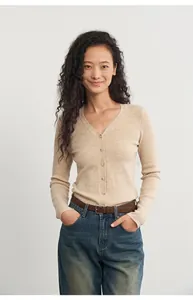 Close-up of model wearing a beige slim-fit knit cardigan with V-neckline.