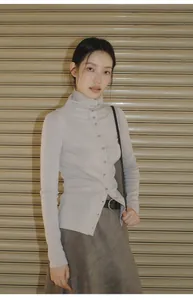Full view of a brown asymmetrical suede-style skirt paired with a lilac turtleneck top