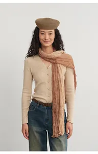 Detailed shot of soft beige knit cardigan paired with gradient scarf on model