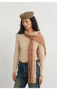 Elegant Asian woman styling a beige knit cardigan with a gradient pleated scarf.