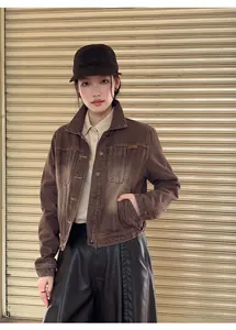 Detail view of a brown gradient wash denim jacket on an Asian model in urban setting