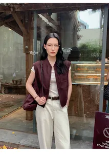 Gilet in camoscio marrone scuro stile Maillard da donna sopra una maglietta bianca al caffè