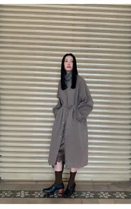Full detail view of a satin lace spliced irregular skirt worn with a vintage trench coat.