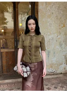 Modella indossa una gonna midi svasata marrone stampata a vita alta con top verde.