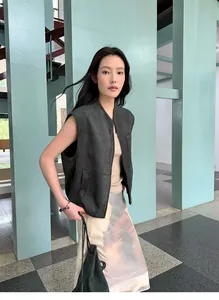Gilet in camoscio grigio antracite da donna con gonna fantasia in un contesto urbano