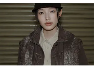 Close-up detail of vintage washed denim jacket with gradient texture on an Asian model