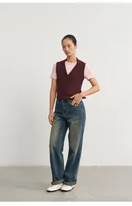 Burgunderfarbene Strickweste für Damen mit rosa T-Shirt und weiter Jeans