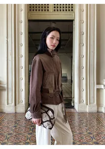 Modella indossa una giacca di jeans marrone lavato vintage con cintura in vita