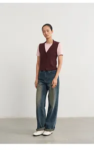 Modische weinrote Damen-Strickweste mit Polo-Kragen, kombiniert mit legeren Jeans.