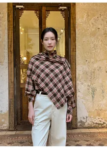 Top a scialle asimmetrico a quadri marroni retrò indossato da una modella in stile vintage