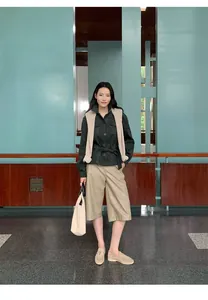 Full-length view of beige PU leather culottes styled with a dark shirt and loafers.