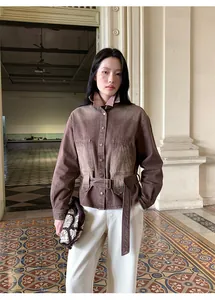 Dettaglio della giacca di jeans vintage sfumata da donna con cintura in vita.