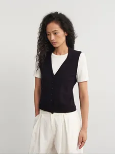 Frauen minimalistische schwarze Strickweste mit klassischem Polo-Kragen im Studio-Look