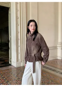 Vista completa di camicia di jeans vintage sfumata con cintura e pantaloni bianchi.