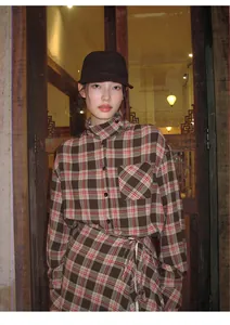 Modella asiatica con scialle a quadri marrone retrò e grembiule in stile vintage
