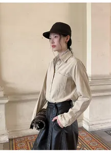 Model wearing high-waisted black faux leather wide-leg pants in an elegant setting