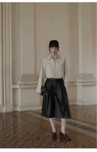 Full-body shot of model wearing oversized high-waisted black PU leather wide-leg culottes