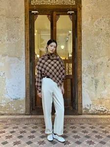 Top a grembiule scialle a quadri retrò con pantaloni bianchi in un ambiente vintage