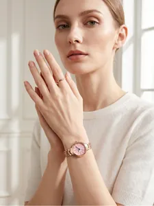 Elegant rose gold business watch with pink dial shown on wrist with a minimalist ring.