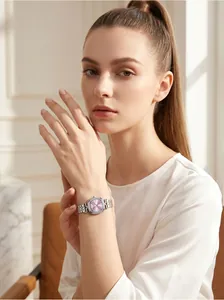 Elegante reloj de acero plateado con esfera ovalada púrpura en la muñeca mujer detalle