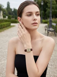 Close-up of a vintage square Gedi watch with glitter dial and burgundy leather strap