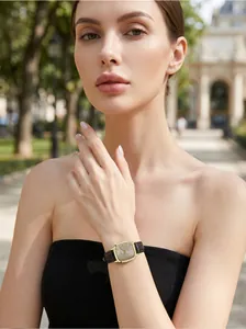 Lifestyle view of a GEDI women watch with a square gold face and black leather strap.