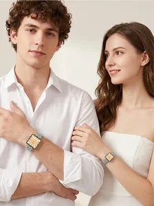 Pareja con relojes de cuarzo cuadrados vintage con correas de acero sobre fondo liso.