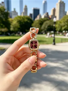 Close-up of GEDI gold chain watch with square burgundy dial for elegant daily commute