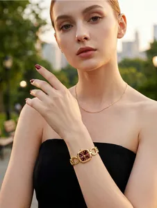 Elegant GEDI gold chain watch with burgundy square dial shown on female wrist.