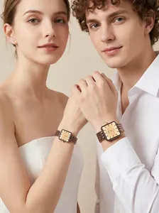 Primer plano de los relojes Gedi de cuarzo cuadrados retro usados por una pareja.