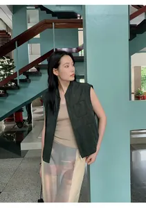 Gilet moderno in pelle scamosciata scura da donna in un ambiente architettonico