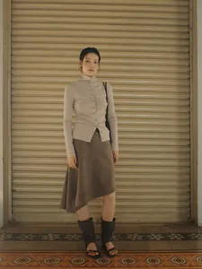 Retro Maillard style brown asymmetrical A-line skirt worn by model in urban street setting
