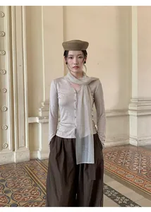 Detail van een elegante Koreaanse gebreide top met V-hals en een verfijnde mesh sjaal.