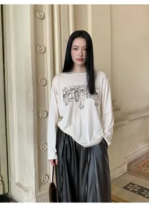 Camiseta de manga larga con bordado artístico llevada por modelo en interior clásico