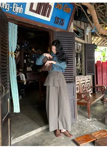 High-waisted fake two-piece grey wide-leg pants paired with a denim shirt in retro cafe.