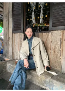 Jean bleu délavé vintage à taille haute avec un trench-coat beige classique chic
