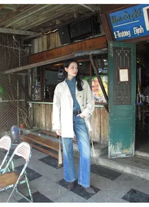 Mannequin élégant portant un jean délavé à taille haute rétro devant un café au style rustique