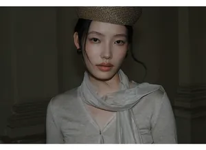 Detailopname van een gebreide top met V-hals en een mesh sjaal in Koreaanse stijl