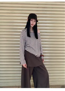 Asian model posing in a brown striped off-shoulder blouse and matching wide-leg trousers.