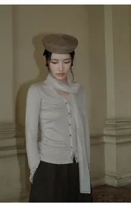 Elegante gebreide top met V-hals en chique mesh sjaaldetail getoond op een model