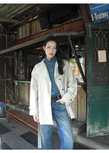 Modèle portant un jean denim vintage dans un café de rue nostalgique pour une vue détail.