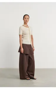 Elegant faux two-piece brown wide-leg skirt trousers styled with a cream knit top on a model