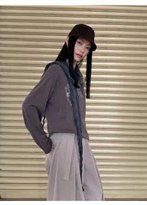 Modelo asiática con camiseta bordada de manga larga marrón oscuro y detalle de bufanda