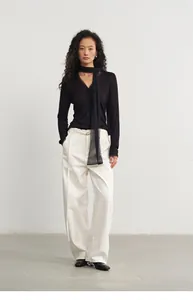 Elegante zwarte gebreide top met V-hals en mesh sjaal detail gecombineerd met witte broek