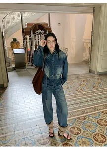 Vue en pied d'un mannequin portant une veste en jean délavé rétro et un jean large taille haute