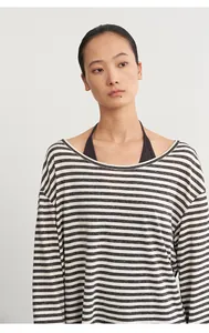 Detailed close-up of striped long-sleeve blouse layered with dark halter-neck top