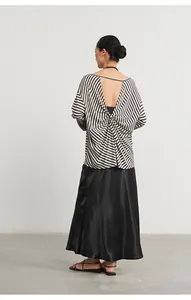 Detailed back view of a chic black and white striped backless knit top with twist detail.