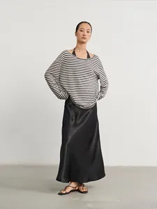 Oversized striped knit sweater and black satin skirt two-piece outfit on Asian model